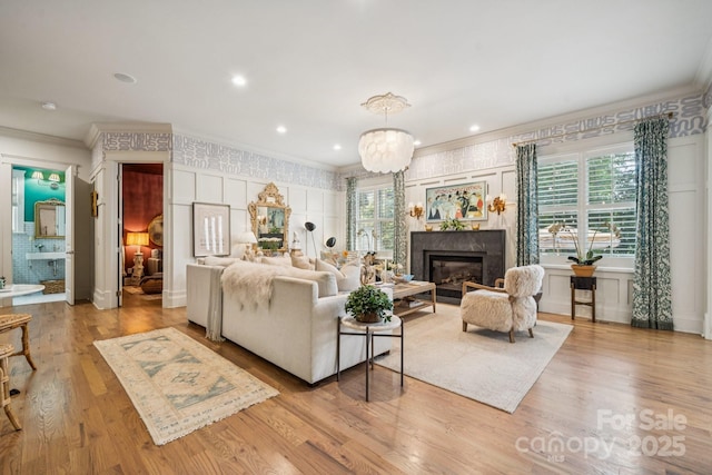 3519 Mcpherson St, Waxhaw, NC 28173 - living area with crown molding, a fireplace, wood finished floors, a chandelier, and recessed lighting