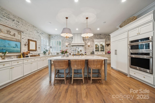 3519 Mcpherson St, Waxhaw, NC 28173 - kitchen with wallpapered walls, white cabinets, light countertops, a kitchen bar, and a kitchen island
