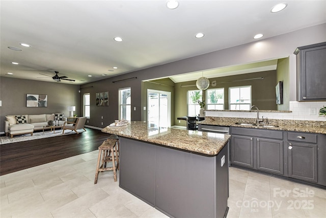 3533 Catherine Creek Pl, Davidson, NC 28036 - kitchen featuring a ceiling fan, a kitchen island, plenty of natural light, recessed lighting, and light stone countertops