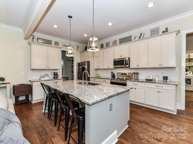 618 Deese Rd, Monroe, NC 28110 - kitchen with crown molding, a breakfast bar area, appliances with stainless steel finishes, tasteful backsplash, and a kitchen island with sink