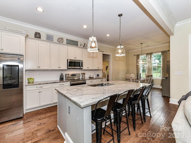 618 Deese Rd, Monroe, NC 28110 - kitchen featuring appliances with stainless steel finishes, crown molding, a breakfast bar, white cabinets, and an island with sink