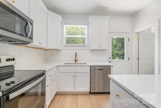 782 Stanley Spencer Mtn Rd, Gastonia, NC 28056 - kitchen with appliances with stainless steel finishes, white cabinets, and light wood-style floors