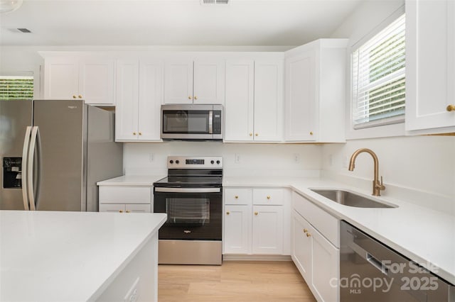 782 Stanley Spencer Mtn Rd, Gastonia, NC 28056 - kitchen featuring stainless steel appliances, healthy amount of natural light, white cabinets, and light wood-style flooring