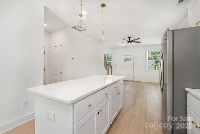 782 Stanley Spencer Mtn Rd, Gastonia, NC 28056 - kitchen featuring freestanding refrigerator, light wood-style flooring, a ceiling fan, and white cabinetry