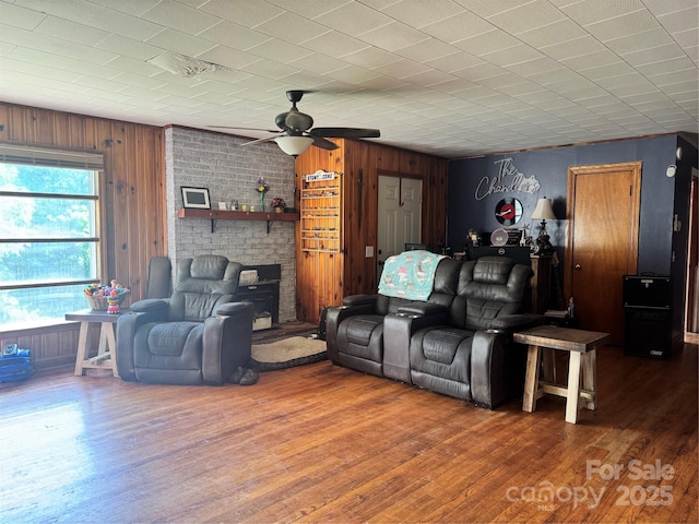 140 Wallins Way, Mars Hill, NC 28754 - living area featuring wooden walls, wood finished floors, a ceiling fan, and a fireplace
