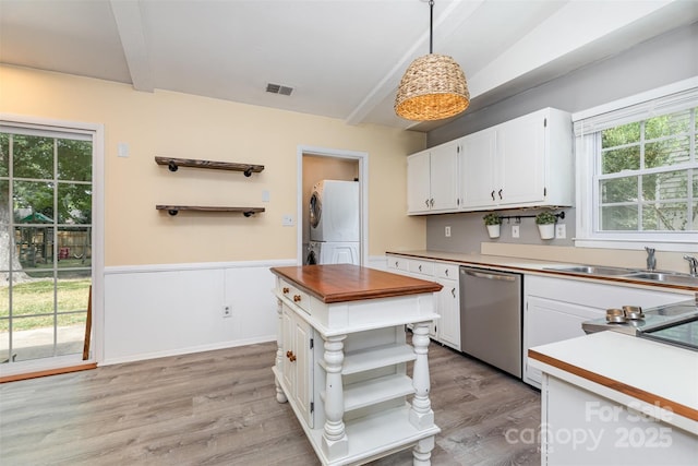 7017 Brookgreen Ter, Matthews, NC 28104 - kitchen with stacked washing machine and dryer, dishwasher, open shelves, white cabinets, and light wood-style flooring