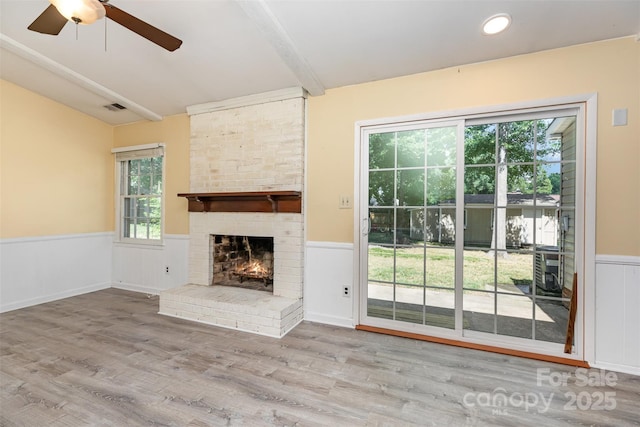 7017 Brookgreen Ter, Matthews, NC 28104 - unfurnished living room with a wainscoted wall, a ceiling fan, a brick fireplace, vaulted ceiling, and wood finished floors