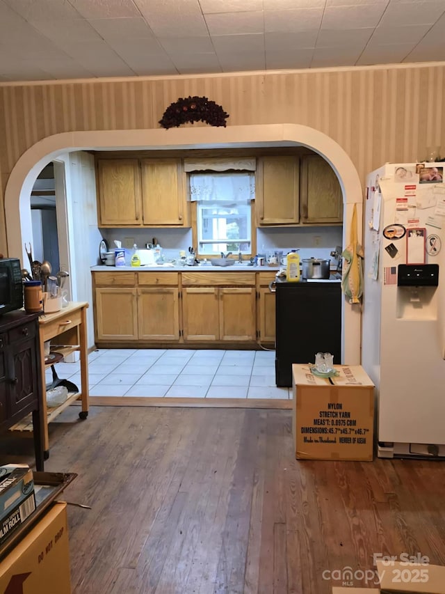 7601 Rhodhiss Rd, Connelly Springs, NC 28612 - kitchen featuring freestanding refrigerator, wallpapered walls, arched walkways, light wood-type flooring, and light countertops