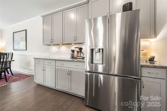 1240 Pebble Grove Dr, Clover, SC 29710 - kitchen with stainless steel fridge with ice dispenser, light stone countertops, dark wood-style flooring, ornamental molding, and a wainscoted wall