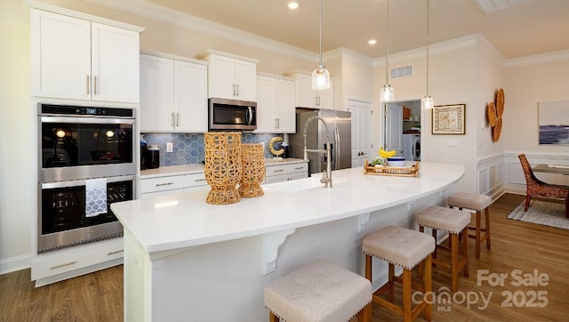 4129 Duplin Dr, Charlotte, NC 28214 - kitchen featuring stainless steel appliances, washer / dryer, ornamental molding, a kitchen breakfast bar, and a spacious island