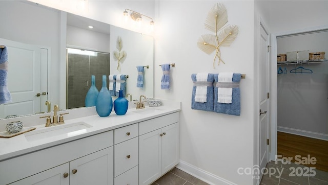 4129 Duplin Dr, Charlotte, NC 28214 - full bath featuring double vanity, a stall shower, a spacious closet, and tile patterned floors