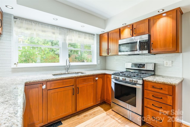 1220 Merribrook Dr, Matthews, NC 28105 - kitchen with stainless steel appliances, light stone countertops, brown cabinets, decorative backsplash, and recessed lighting