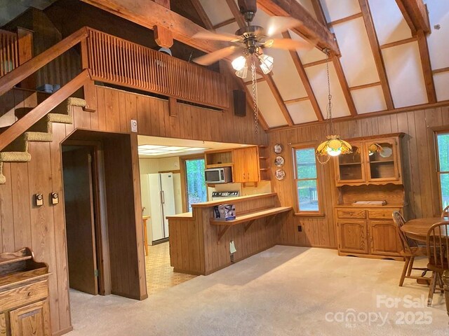 268 Poor Boy Ln, Whittier, NC 28789 - kitchen featuring stainless steel microwave, wood walls, freestanding refrigerator, a ceiling fan, and light colored carpet