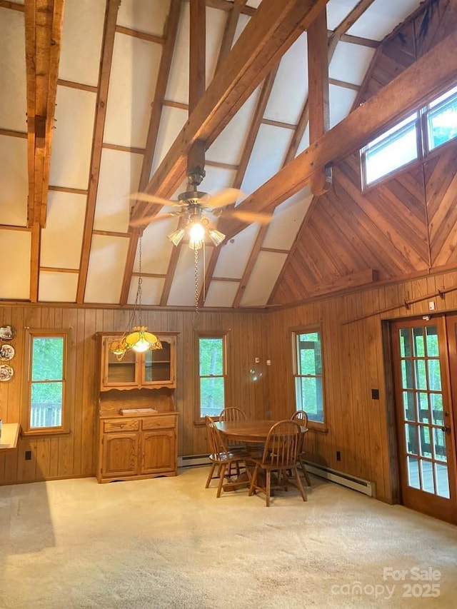 268 Poor Boy Ln, Whittier, NC 28789 - unfurnished dining area featuring wood walls, beamed ceiling, ceiling fan, healthy amount of natural light, and carpet