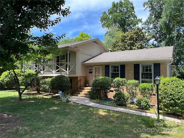 5938 Sharon Rd, Charlotte, NC 28210 - split level home with a front lawn, brick siding, and roof with shingles