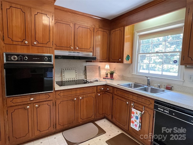 5938 Sharon Rd, Charlotte, NC 28210 - kitchen featuring black appliances, under cabinet range hood, brown cabinets, and light countertops
