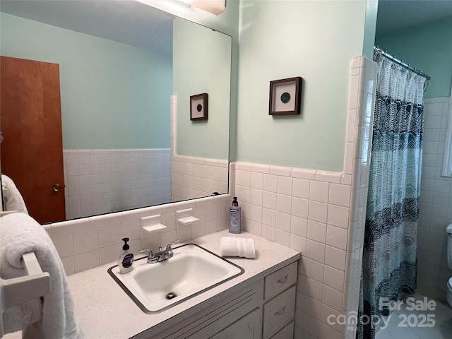 5938 Sharon Rd, Charlotte, NC 28210 - full bathroom featuring tile walls, vanity, a wainscoted wall, and curtained shower