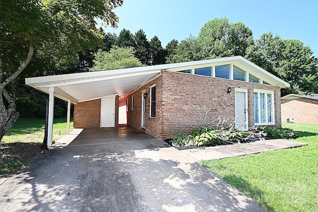 112 Lovelady Rd, Valdese, NC 28690 - mid-century inspired home featuring a front yard, brick siding, driveway, and a carport