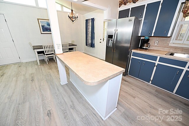 112 Lovelady Rd, Valdese, NC 28690 - kitchen with blue cabinetry, stainless steel fridge, light wood finished floors, light countertops, and a chandelier