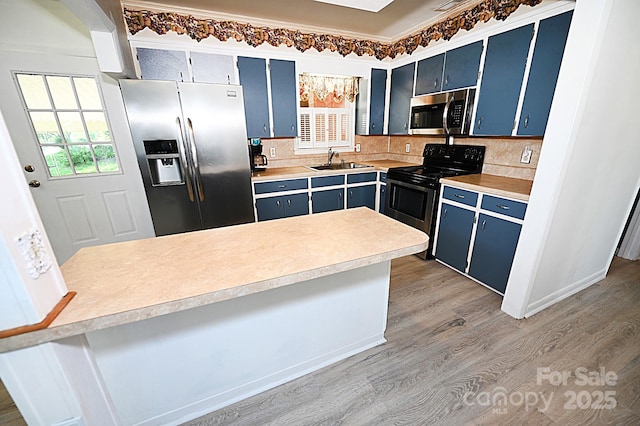 112 Lovelady Rd, Valdese, NC 28690 - kitchen featuring appliances with stainless steel finishes, blue cabinets, light wood-style flooring, and light countertops