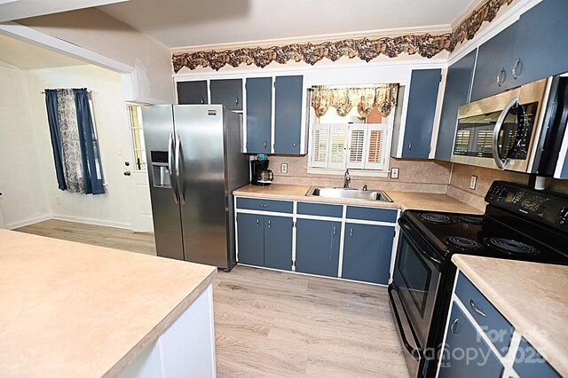 112 Lovelady Rd, Valdese, NC 28690 - kitchen featuring appliances with stainless steel finishes, blue cabinetry, light wood finished floors, light countertops, and crown molding