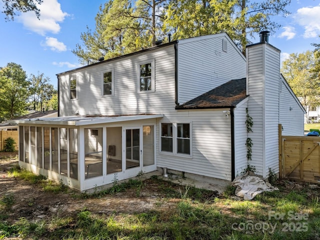 4918 Tyne Dr, Durham, NC 27703 - rear view of house featuring a sunroom, a chimney, and a shingled roof