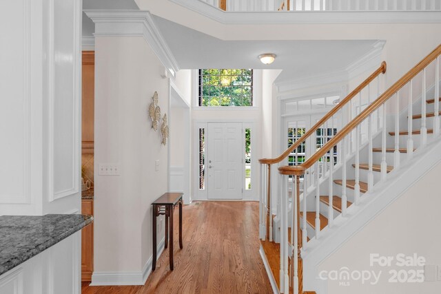 8606 Gresham Dr, Waxhaw, NC 28173 - foyer with light wood-style flooring, stairway, a high ceiling, and ornamental molding
