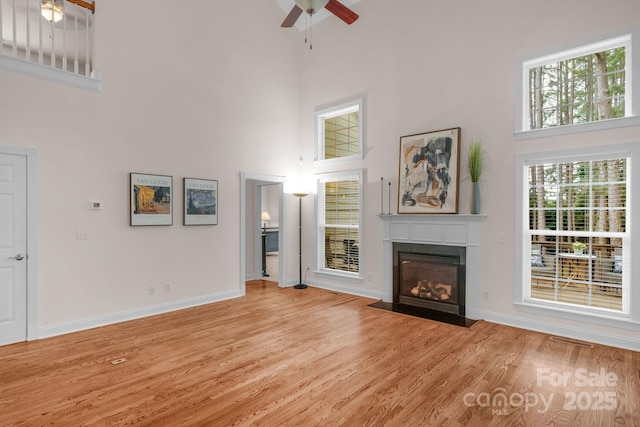8606 Gresham Dr, Waxhaw, NC 28173 - unfurnished living room featuring a high ceiling, a ceiling fan, wood finished floors, and a fireplace with flush hearth