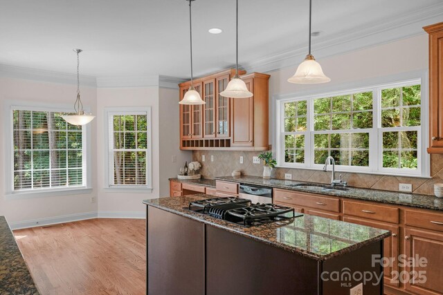 8606 Gresham Dr, Waxhaw, NC 28173 - kitchen featuring black gas cooktop, tasteful backsplash, crown molding, light wood-type flooring, and dark stone countertops