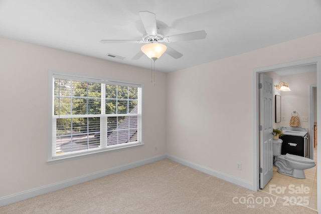 8606 Gresham Dr, Waxhaw, NC 28173 - unfurnished bedroom featuring light colored carpet, ceiling fan, and ensuite bath