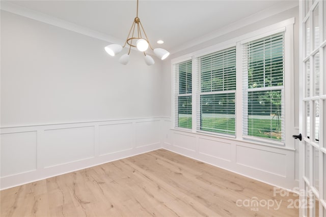4114 Mantle Ct, Charlotte, NC 28205 - unfurnished dining area featuring a chandelier, ornamental molding, wainscoting, a decorative wall, and wood finished floors
