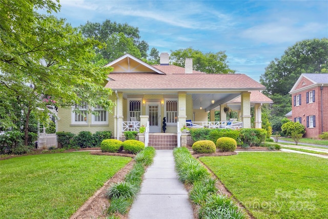 156 Union St N, Concord, NC 28025 - view of front of home featuring a chimney, a front lawn, a porch, and brick siding