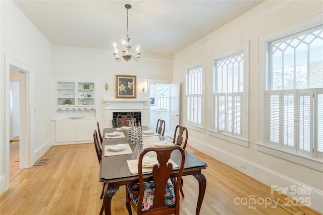 156 Union St N, Concord, NC 28025 - dining area with a chandelier, light wood-type flooring, and a fireplace