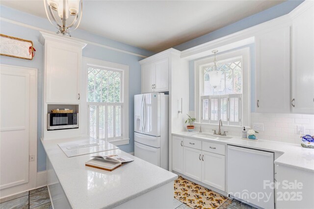 156 Union St N, Concord, NC 28025 - kitchen with white appliances, white cabinets, light countertops, and hanging light fixtures