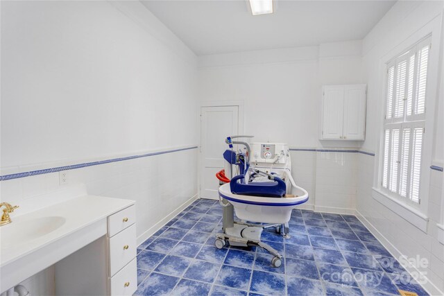 156 Union St N, Concord, NC 28025 - full bath featuring tile patterned floors, a wainscoted wall, a freestanding tub, and tile walls
