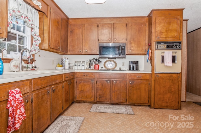 511 E Church St, Kershaw, SC 29067 - kitchen featuring stainless steel microwave, white oven, light countertops, light flooring, and brown cabinets