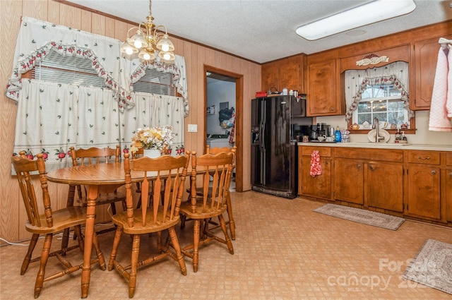 511 E Church St, Kershaw, SC 29067 - dining space with light flooring, crown molding, a chandelier, wooden walls, and a textured ceiling