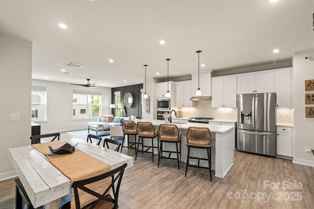 932 Portrush Ln, Tega Cay, SC 29708 - kitchen featuring stainless steel appliances, a center island with sink, recessed lighting, light countertops, and a kitchen breakfast bar