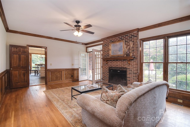 1482 Willow Oaks Trl, Matthews, NC 28104 - living area with a wainscoted wall, wood finished floors, ceiling fan, a brick fireplace, and crown molding