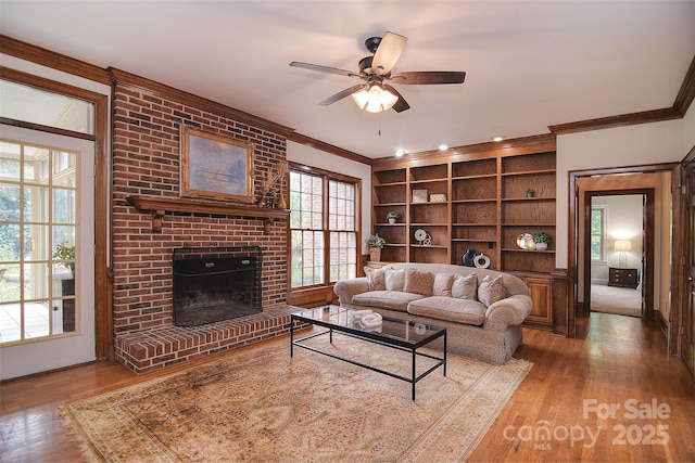 1482 Willow Oaks Trl, Matthews, NC 28104 - living area with crown molding, wood finished floors, ceiling fan, a fireplace, and built in shelves