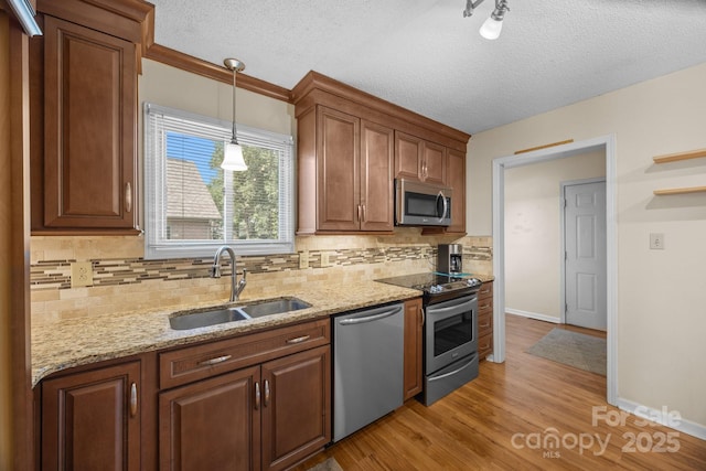840 Deer Lake Run, Salisbury, NC 28146 - kitchen featuring appliances with stainless steel finishes, tasteful backsplash, light stone counters, pendant lighting, and light wood-style flooring