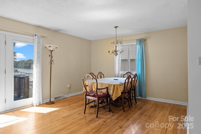 840 Deer Lake Run, Salisbury, NC 28146 - dining room featuring light wood-style flooring, a chandelier, and a textured ceiling