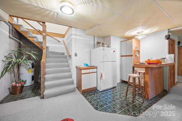 840 Deer Lake Run, Salisbury, NC 28146 - kitchen featuring freestanding refrigerator, electric water heater, concrete block wall, and a drop ceiling