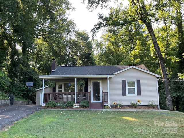 517 Stowe Dr, Lowell, NC 28098 - single story home with covered porch, a chimney, a front lawn, view of scattered trees, and asphalt driveway