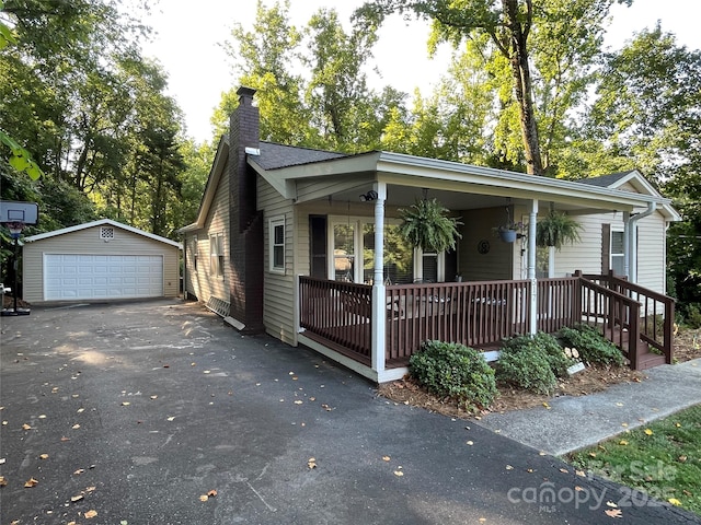 517 Stowe Dr, Lowell, NC 28098 - view of front facade featuring a chimney, an outdoor structure, a detached garage, and covered porch