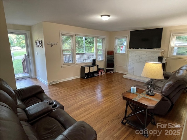517 Stowe Dr, Lowell, NC 28098 - living room featuring wood finished floors and a brick fireplace
