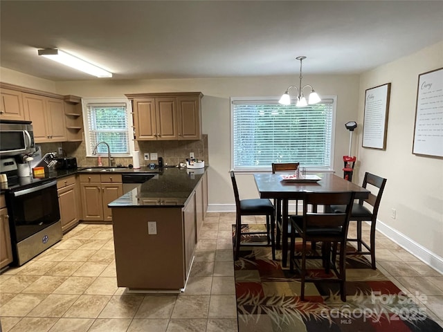 517 Stowe Dr, Lowell, NC 28098 - kitchen with stainless steel appliances, decorative backsplash, a chandelier, a peninsula, and decorative light fixtures