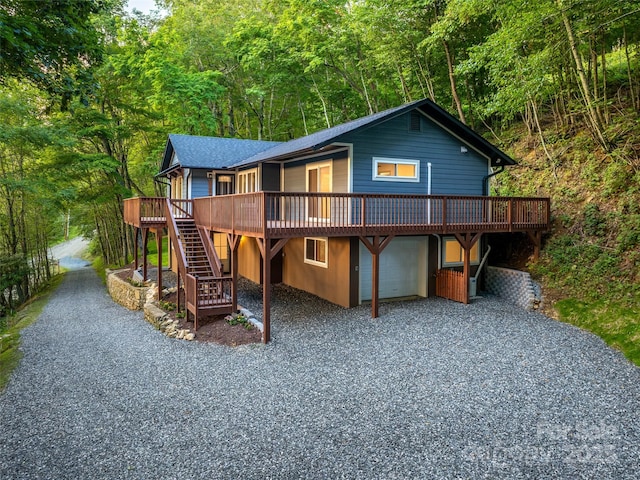 1065 Oak Ridge Ln, Mars Hill, NC 28754 - chalet / cabin with a wooden deck, gravel driveway, a garage, stairway, and a view of trees