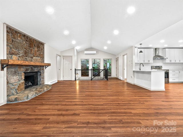 1065 Oak Ridge Ln, Mars Hill, NC 28754 - unfurnished living room with a wall unit AC, vaulted ceiling, dark wood finished floors, a stone fireplace, and recessed lighting