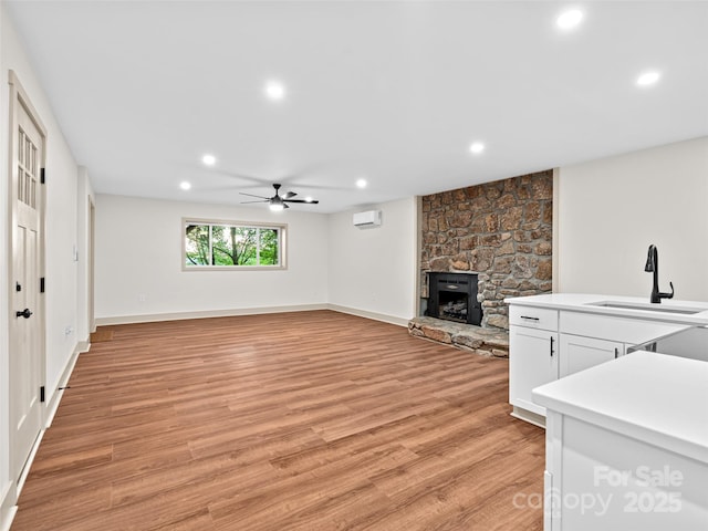 1065 Oak Ridge Ln, Mars Hill, NC 28754 - unfurnished living room featuring light wood-style floors, a stone fireplace, recessed lighting, a ceiling fan, and a wall mounted AC